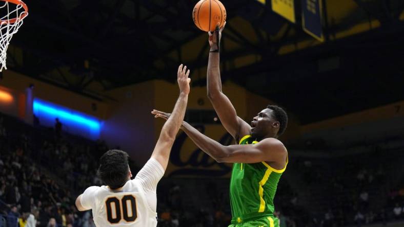 Feb 24, 2024; Berkeley, California, USA; Oregon Ducks center N'Faly Dante (right) shoots against California Golden Bears forward Fardaws Aimaq (00) during the second half at Haas Pavilion. Mandatory Credit: Darren Yamashita-USA TODAY Sports