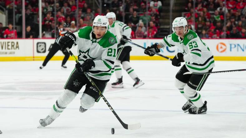 Feb 24, 2024; Raleigh, North Carolina, USA;  Dallas Stars left wing Jason Robertson (21) skates with the puck next to center Wyatt Johnston (53) during the second period against the Carolina Hurricanes at PNC Arena. Mandatory Credit: James Guillory-USA TODAY Sports