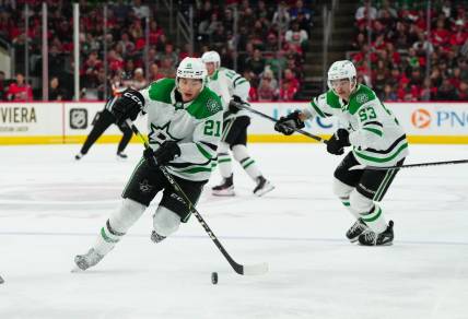Feb 24, 2024; Raleigh, North Carolina, USA;  Dallas Stars left wing Jason Robertson (21) skates with the puck next to center Wyatt Johnston (53) during the second period against the Carolina Hurricanes at PNC Arena. Mandatory Credit: James Guillory-USA TODAY Sports