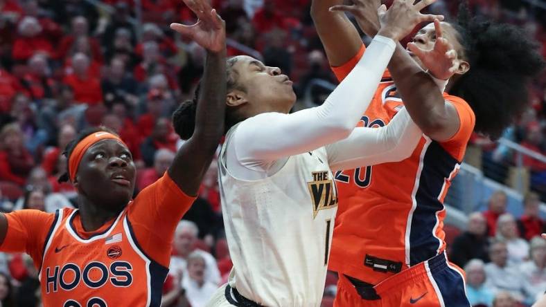 U of L's Merissah Russell (13) gets tied up with Virgina defenders during their game at the KFC Yum! Center in Louisville, Ky. on Feb. 25, 2024.