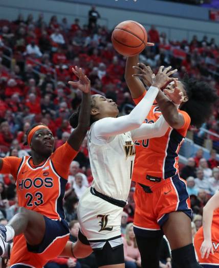 U of L's Merissah Russell (13) gets tied up with Virgina defenders during their game at the KFC Yum! Center in Louisville, Ky. on Feb. 25, 2024.
