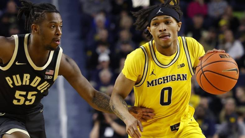 Feb 25, 2024; Ann Arbor, Michigan, USA;  Michigan Wolverines guard Dug McDaniel (0) dribbles against Purdue Boilermakers guard Lance Jones (55) in the first half at Crisler Center. Mandatory Credit: Rick Osentoski-USA TODAY Sports