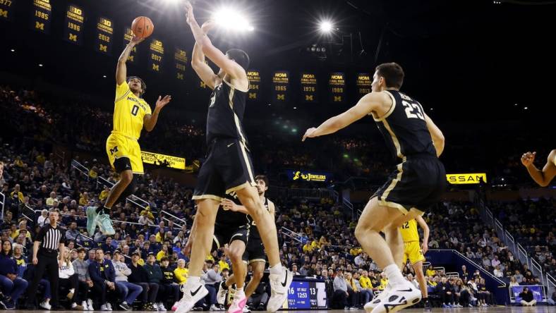 Feb 25, 2024; Ann Arbor, Michigan, USA;  Michigan Wolverines guard Dug McDaniel (0) shoots over Purdue Boilermakers center Zach Edey (15) in the first half at Crisler Center. Mandatory Credit: Rick Osentoski-USA TODAY Sports