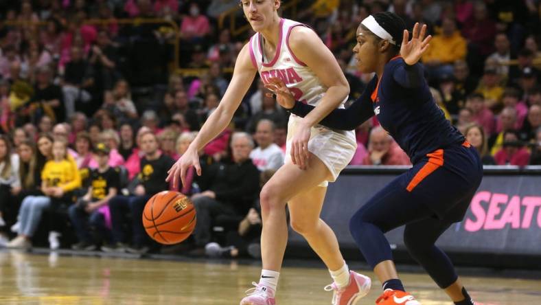 Iowa's Caitlin Clark (22) dribbles as Illinois   s Makira Cook (3) defends Saturday, Feb. 24, 2024 at Carver-Hawkeye Arena.