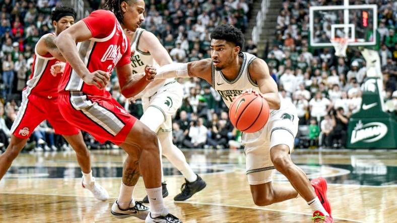 Michigan State's Jaden Akins, right, moves the ball as Ohio State's Devin Royal defends during the first half on Sunday, Feb. 25, 2024, at the Breslin Center in East Lansing.