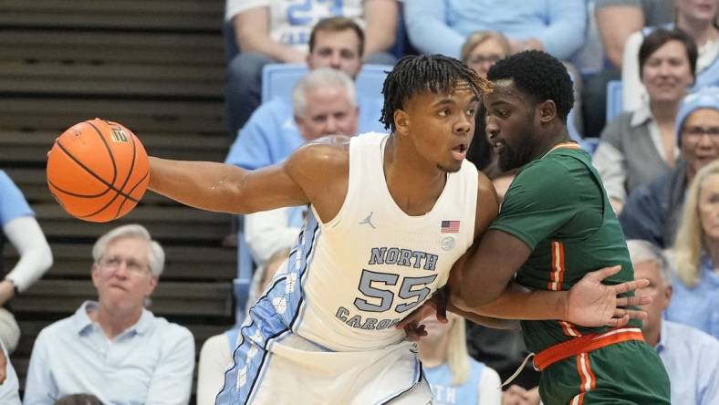 Feb 26, 2024; Chapel Hill, North Carolina, USA; North Carolina Tar Heels forward Harrison Ingram (55) with the ball as Miami (Fl) Hurricanes guard Bensley Joseph (4) defends in the first half at Dean E. Smith Center. Mandatory Credit: Bob Donnan-USA TODAY Sports