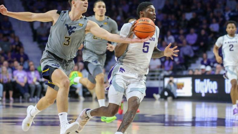 Feb 26, 2024; Manhattan, Kansas, USA; West Virginia Mountaineers guard Kerr Kriisa (3) knocks the ball away from Kansas State Wildcats guard Cam Carter (5) during the first half at Bramlage Coliseum. Mandatory Credit: Scott Sewell-USA TODAY Sports