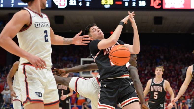 Feb 27, 2024; Dayton, Ohio, USA;  Davidson Wildcats guard Riccardo Ghedini (22) reaches for a rebound against Dayton Flyers forward Nate Santos (2) during the game at University of Dayton Arena. Mandatory Credit: Matt Lunsford-USA TODAY Sports