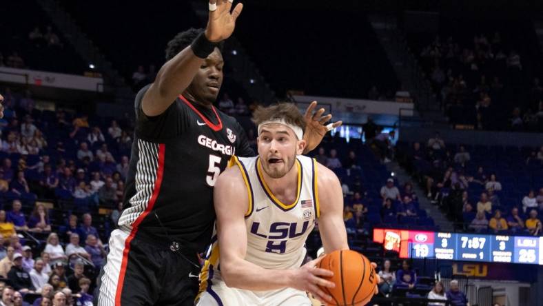 Feb 27, 2024; Baton Rouge, Louisiana, USA; LSU Tigers forward Will Baker (9) dribbles against Georgia Bulldogs center Russel Tchewa (54) during the first half at Pete Maravich Assembly Center. Mandatory Credit: Stephen Lew-USA TODAY Sports