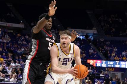 Feb 27, 2024; Baton Rouge, Louisiana, USA; LSU Tigers forward Will Baker (9) dribbles against Georgia Bulldogs center Russel Tchewa (54) during the first half at Pete Maravich Assembly Center. Mandatory Credit: Stephen Lew-USA TODAY Sports