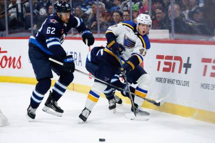 Feb 27, 2024; Winnipeg, Manitoba, CAN; St. Louis Blues defenseman Torey Krug (47) makes a pass against Winnipeg Jets forward Nino Niederreiter (62) during the second period at Canada Life Centre. Mandatory Credit: Terrence Lee-USA TODAY Sports