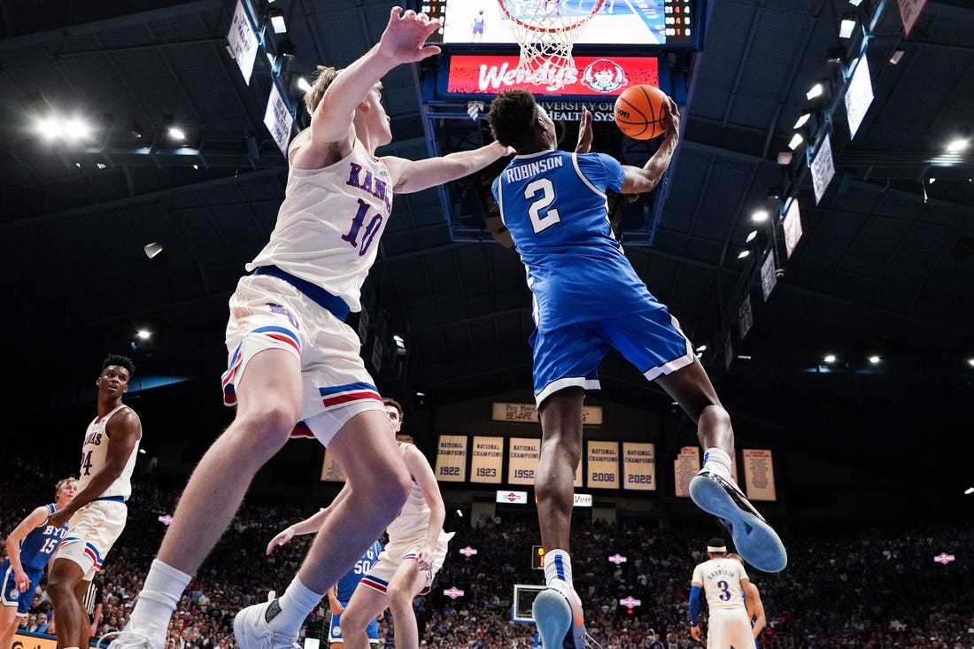 Feb 27, 2024; Lawrence, Kansas, USA; Brigham Young Cougars guard Jaxson Robinson (2) shoots as Kansas Jayhawks guard Johnny Furphy (10) defends during the second half at Allen Fieldhouse. Mandatory Credit: Denny Medley-USA TODAY Sports