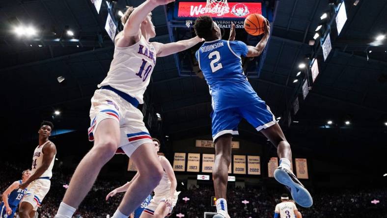 Feb 27, 2024; Lawrence, Kansas, USA; Brigham Young Cougars guard Jaxson Robinson (2) shoots as Kansas Jayhawks guard Johnny Furphy (10) defends during the second half at Allen Fieldhouse. Mandatory Credit: Denny Medley-USA TODAY Sports