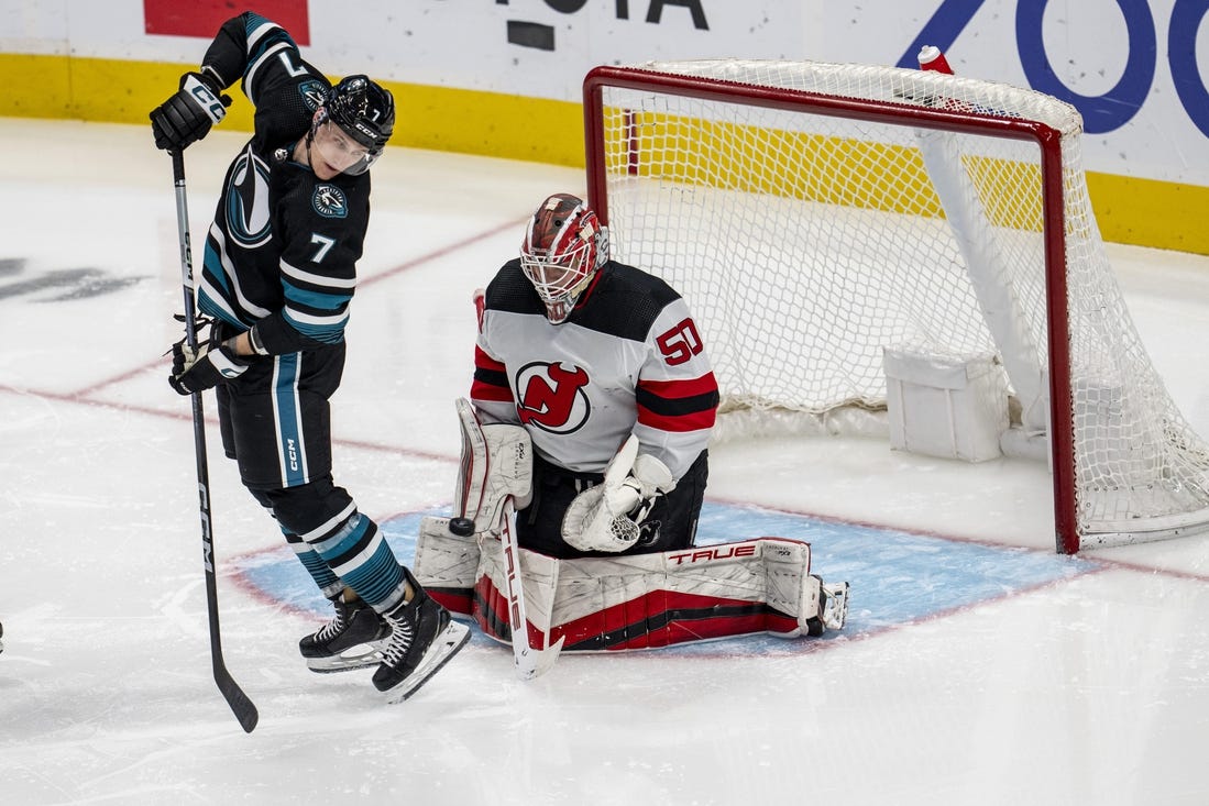 Feb 27, 2024; San Jose, California, USA;  New Jersey Devils goaltender Nico Daws (50) makes a save as San Jose Sharks center Nico Sturm (7) tries to deflect the puck into the net during the third period at SAP Center at San Jose. Mandatory Credit: Neville E. Guard-USA TODAY Sports