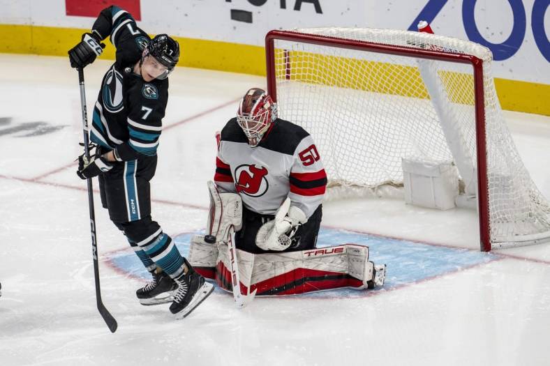 Feb 27, 2024; San Jose, California, USA;  New Jersey Devils goaltender Nico Daws (50) makes a save as San Jose Sharks center Nico Sturm (7) tries to deflect the puck into the net during the third period at SAP Center at San Jose. Mandatory Credit: Neville E. Guard-USA TODAY Sports