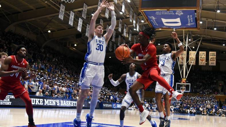 Feb 28, 2024; Durham, North Carolina, USA; Louisville Cardinals guard Ty-Laur Johnson (4) throws a pass around Duke Blue Devils center Kyle Filipowski (30) during the first half at Cameron Indoor Stadium. Mandatory Credit: Rob Kinnan-USA TODAY Sports