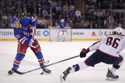 Feb 28, 2024; New York, New York, USA; New York Rangers defenseman Adam Fox (23) takes a shot against Columbus Blue Jackets right wing Kirill Marchenko (86) during the second period at Madison Square Garden. Mandatory Credit: Brad Penner-USA TODAY Sports