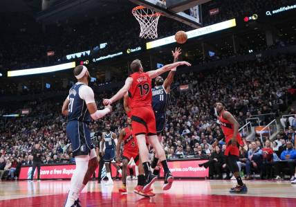 Feb 28, 2024; Toronto, Ontario, CAN; Dallas Mavericks guard Kyrie Irving (11) drives to the basket as Toronto Raptors center Jakob Poeltl (19) tries to defend during the second quarter at Scotiabank Arena. Mandatory Credit: Nick Turchiaro-USA TODAY Sports