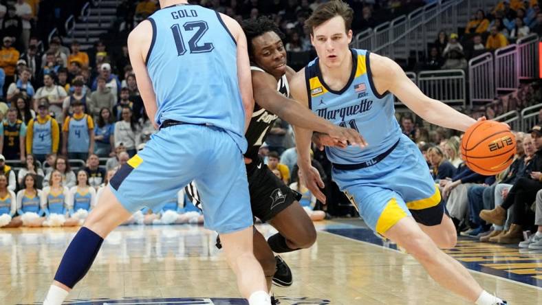 Marquette guard Tyler Kolek (11) takes advantage of a pick by forward Ben Gold (12) on guard Jayden Pierre (1) during the first half of their game Wednesday, February 28, 2024 at Fiserv Forum in Milwaukee, Wisconsin.