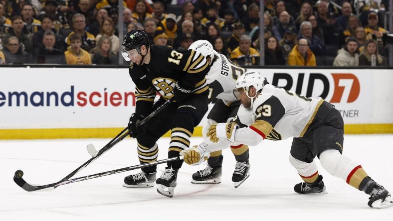 Feb 29, 2024; Boston, Massachusetts, USA; Vegas Golden Knights defenseman Alec Martinez (23) knocks the puck off the stick of Boston Bruins center Charlie Coyle (13) during the first period at TD Garden. Mandatory Credit: Winslow Townson-USA TODAY Sports