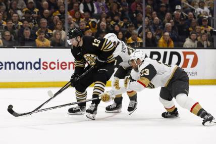 Feb 29, 2024; Boston, Massachusetts, USA; Vegas Golden Knights defenseman Alec Martinez (23) knocks the puck off the stick of Boston Bruins center Charlie Coyle (13) during the first period at TD Garden. Mandatory Credit: Winslow Townson-USA TODAY Sports