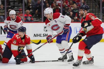 Feb 29, 2024; Sunrise, Florida, USA; Montreal Canadiens center Nick Suzuki (14) watches his shot against the Florida Panthers during the first period at Amerant Bank Arena. Mandatory Credit: Sam Navarro-USA TODAY Sports