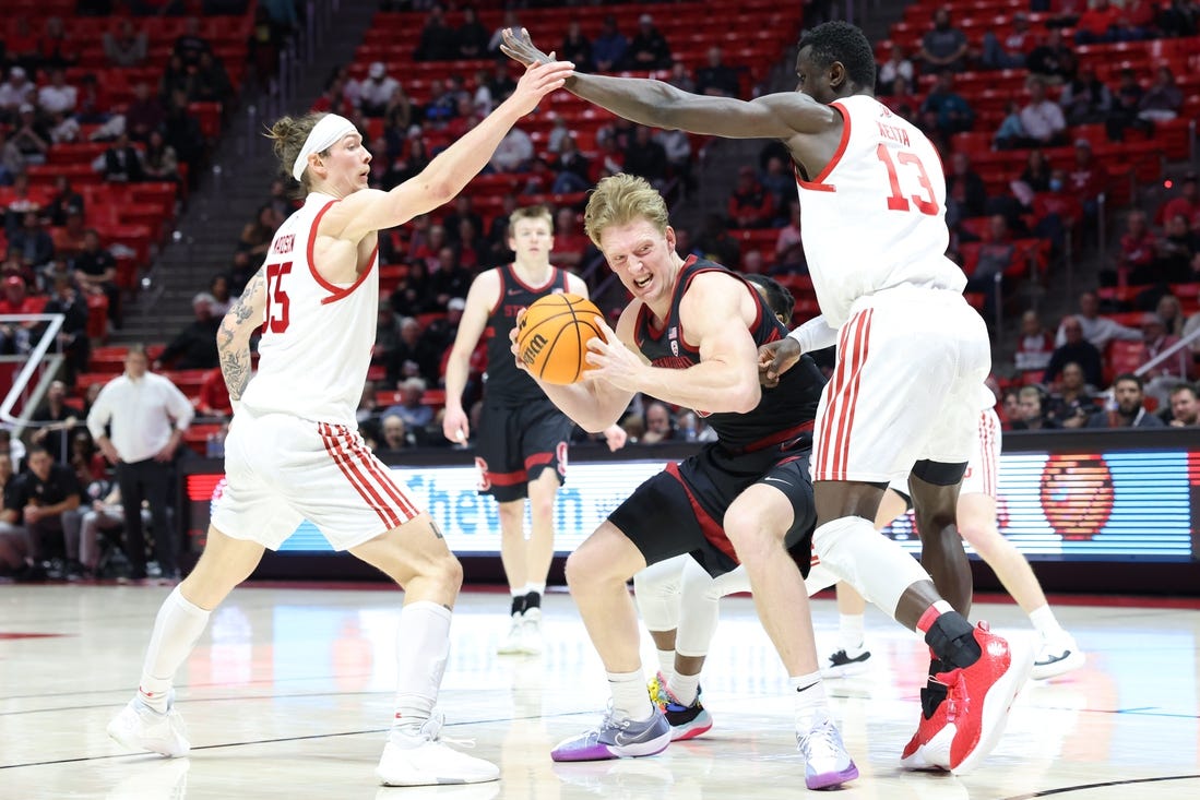 Feb 29, 2024; Salt Lake City, Utah, USA; Stanford Cardinal forward James Keefe (22) drives between Utah Utes guard Gabe Madsen (55) and center Keba Keita (13) during the first half at Jon M. Huntsman Center. Mandatory Credit: Rob Gray-USA TODAY Sports