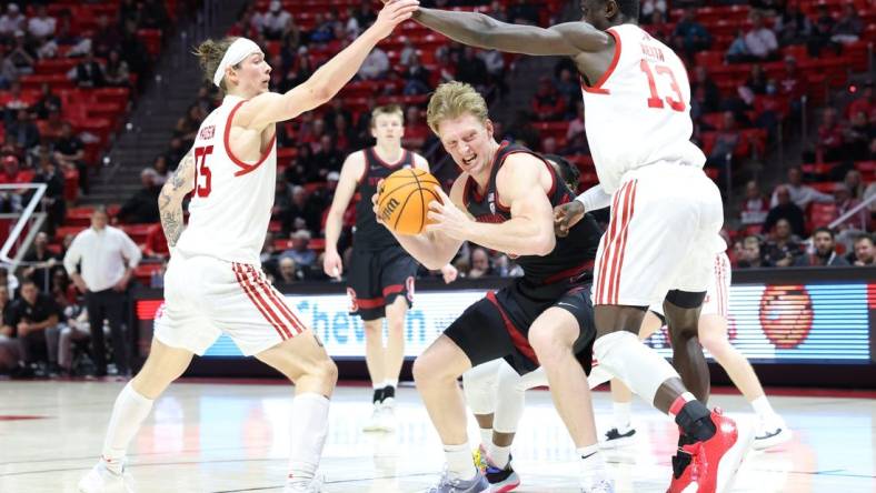 Feb 29, 2024; Salt Lake City, Utah, USA; Stanford Cardinal forward James Keefe (22) drives between Utah Utes guard Gabe Madsen (55) and center Keba Keita (13) during the first half at Jon M. Huntsman Center. Mandatory Credit: Rob Gray-USA TODAY Sports