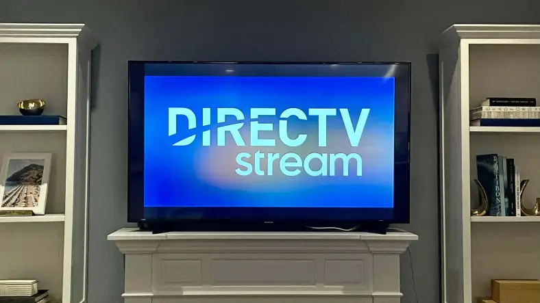 DIRECTV STREAM logo on a TV in a living room next to bookshelves