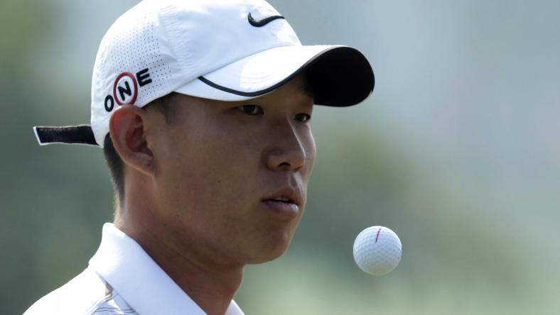 Anthony Kim of the U.S. reaches for the ball as he plays on the 1th hole during the 2009 HSBC Champions golf tournament in Shanghai November 5, 2009.