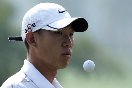 Anthony Kim of the U.S. reaches for the ball as he plays on the 1th hole during the 2009 HSBC Champions golf tournament in Shanghai November 5, 2009.