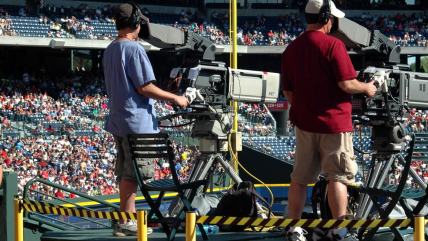 2 camera men standing in a green metal stage during daytime