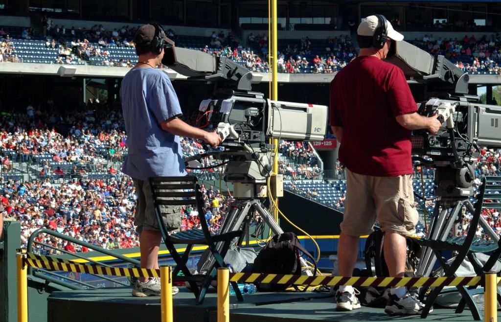 2 camera men standing in a green metal stage during daytime