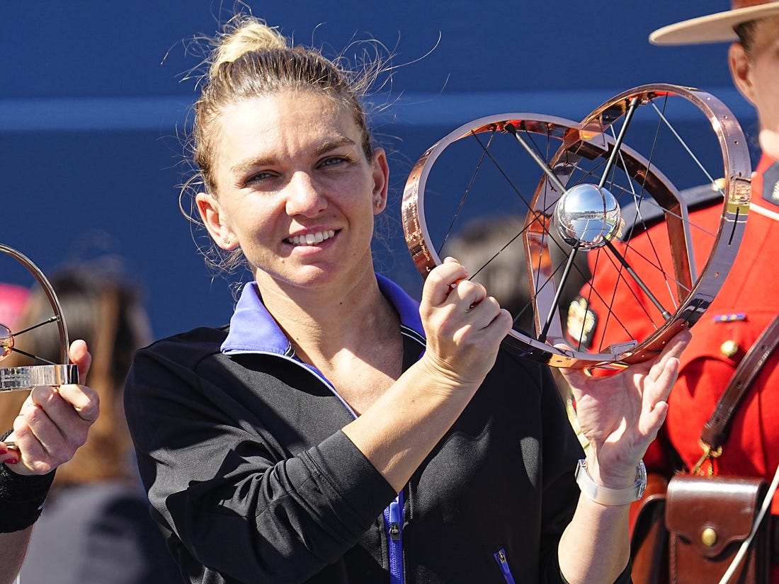 Aug 14, 2022; Toronto, ON, Canada; Simona Halep (ROU) poses with the National Bank Open trophy after defeating Beatriz Haddad Maia (not pictured)  in the women's final of the National Bank Open at Sobeys Stadium. Mandatory Credit: John E. Sokolowski-USA TODAY Sports