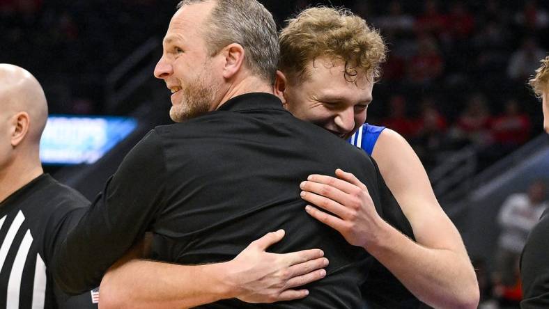 Mar 5, 2023; St. Louis, MO, USA; Drake Bulldogs guard Tucker DeVries (12) celebrates with head coach Darian DeVries during the second half against the Bradley Braves in the finals of the Missouri Valley Conference Tournament at Enterprise Center. Mandatory Credit: Jeff Curry-USA TODAY Sports