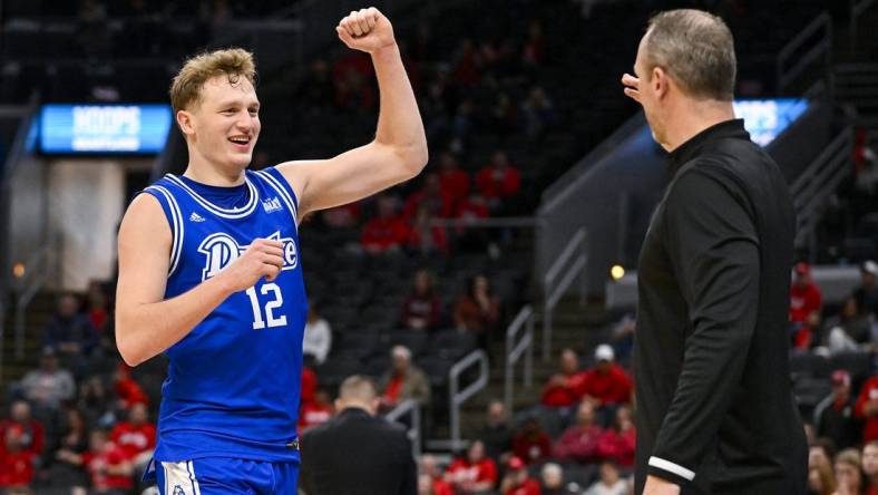 Mar 5, 2023; St. Louis, MO, USA; Drake Bulldogs guard Tucker DeVries (12) celebrates with head coach Darian DeVries during the second half against the Bradley Braves in the finals of the Missouri Valley Conference Tournament at Enterprise Center. Mandatory Credit: Jeff Curry-USA TODAY Sports