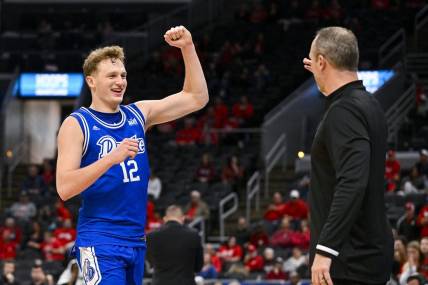 Mar 5, 2023; St. Louis, MO, USA; Drake Bulldogs guard Tucker DeVries (12) celebrates with head coach Darian DeVries during the second half against the Bradley Braves in the finals of the Missouri Valley Conference Tournament at Enterprise Center. Mandatory Credit: Jeff Curry-USA TODAY Sports