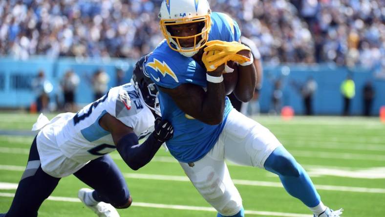 Sep 17, 2023; Nashville, Tennessee, USA; Los Angeles Chargers wide receiver Mike Williams (81) runs after a catch against Tennessee Titans cornerback Tre Avery (23) during the first half at Nissan Stadium. Mandatory Credit: Christopher Hanewinckel-USA TODAY Sports