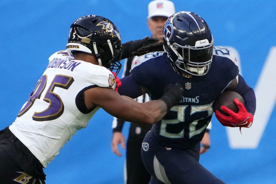 Oct 15, 2023; London, United Kingdom; Tennessee Titans running back Derrick Henry (22) carries the ball against Baltimore Ravens linebacker Tavius Robinson (95) in the second half during an NFL International Series game at Tottenham Hotspur Stadium. Mandatory Credit: Kirby Lee-USA TODAY Sports