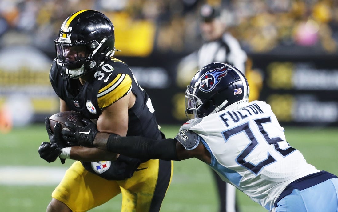 Nov 2, 2023; Pittsburgh, Pennsylvania, USA;  Pittsburgh Steelers running back Jaylen Warren (30) runs against Tennessee Titans cornerback Kristian Fulton (26) during the third quarter at Acrisure Stadium. Pittsburgh won 20-16. Mandatory Credit: Charles LeClaire-USA TODAY Sports