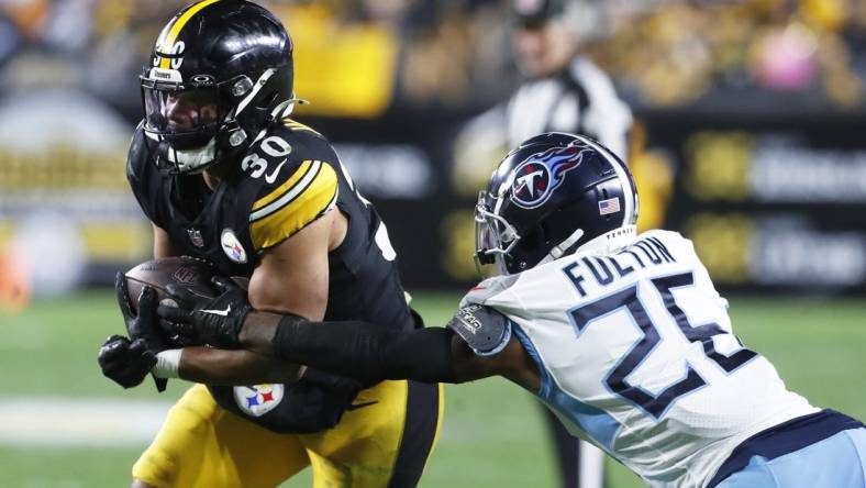 Nov 2, 2023; Pittsburgh, Pennsylvania, USA;  Pittsburgh Steelers running back Jaylen Warren (30) runs against Tennessee Titans cornerback Kristian Fulton (26) during the third quarter at Acrisure Stadium. Pittsburgh won 20-16. Mandatory Credit: Charles LeClaire-USA TODAY Sports