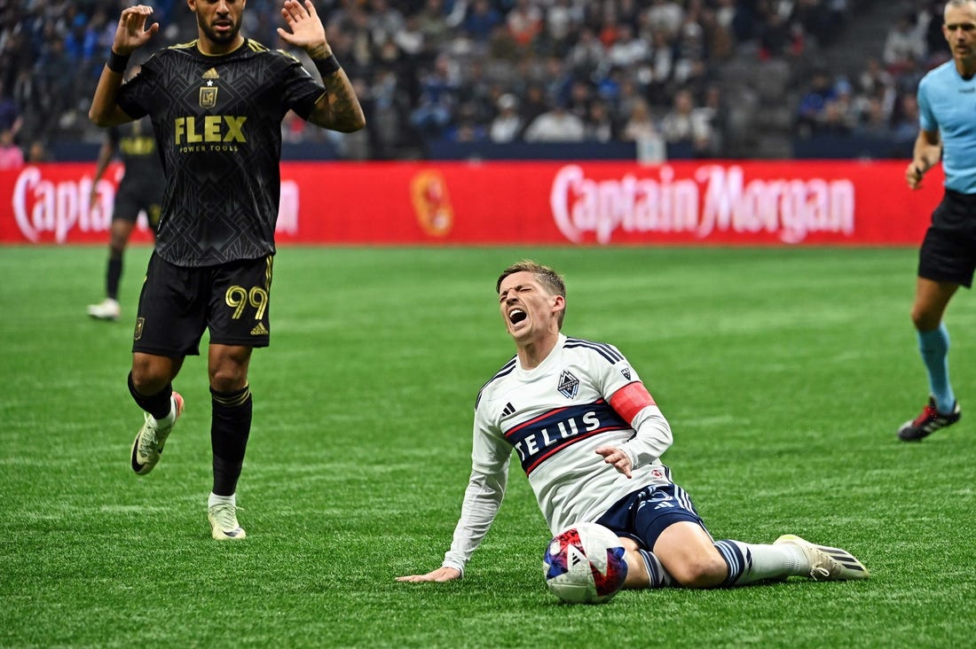 Nov 5, 2023; Vancouver, British Columbia, CAN; Vancouver Whitecaps midfielder Ryan Gauld (25) falls to the pitch against Los Angeles FC forward Denis Bouanga (99) during the second half of game two in a round one match of the 2023 MLS Cup Playoffs at BC Place. Mandatory Credit: Simon Fearn-USA TODAY Sports