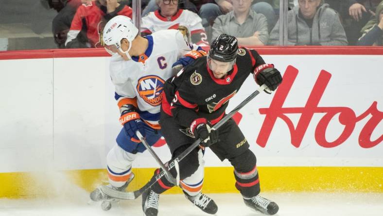 Nov 24 2023; Ottawa, Ontario, CAN; New York Islanders left wing Anders Lee (27) battles with Ottawa Senators defenseman Artem Zub (2) in the third period at the Canadian Tire Centre. Mandatory Credit: Marc DesRosiers-USA TODAY Sports