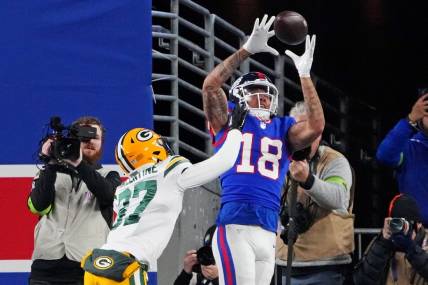 Dec 11, 2023; East Rutherford, New Jersey, USA; New York Giants wide receiver Isaiah Hodgins (18) catches a touchdown against Green Bay Packers cornerback Carrington Valentine (37) during the third quarter at MetLife Stadium. Mandatory Credit: Robert Deutsch-USA TODAY Sports