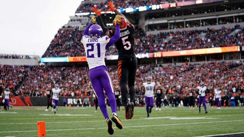 Cincinnati Bengals wide receiver Tee Higgins (5) catches a touchdown pass as Minnesota Vikings cornerback Akayleb Evans (21) defends in the fourth quarter of a Week 15 NFL football game between the Minnesota Vikings and the Cincinnati Bengals, Saturday, Dec. 16, 2023, at Paycor Stadium in Cincinnati. The Cincinnati Bengals won 27-24 in overtime.