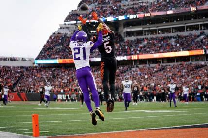 Cincinnati Bengals wide receiver Tee Higgins (5) catches a touchdown pass as Minnesota Vikings cornerback Akayleb Evans (21) defends in the fourth quarter of a Week 15 NFL football game between the Minnesota Vikings and the Cincinnati Bengals, Saturday, Dec. 16, 2023, at Paycor Stadium in Cincinnati. The Cincinnati Bengals won 27-24 in overtime.