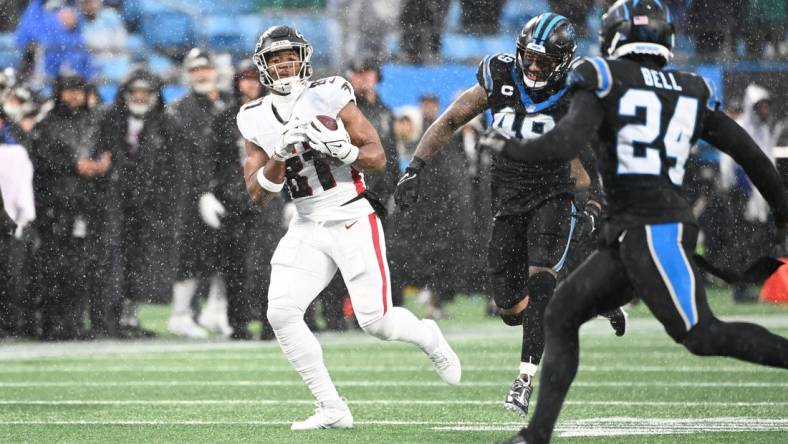 Dec 17, 2023; Charlotte, North Carolina, USA; Atlanta Falcons tight end Jonnu Smith (81) catches the ball as Carolina Panthers linebacker Frankie Luvu (49) and safety Vonn Bell (24) defend in the second quarter at Bank of America Stadium. Mandatory Credit: Bob Donnan-USA TODAY Sports