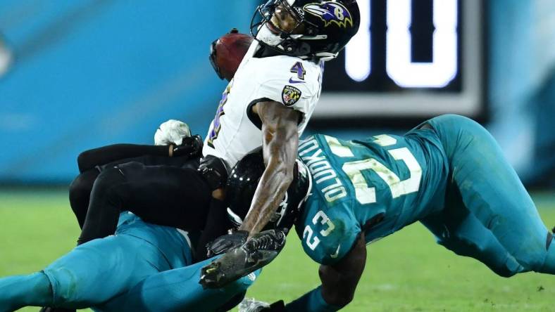 Jacksonville Jaguars cornerback Montaric Brown (30) and linebacker Foyesade Oluokun (23) make the tackle on Baltimore Ravens wide receiver Zay Flowers (4) during third quarter action. The Jacksonville Jaguars hosted the Baltimore Ravens at EverBank Stadium in Jacksonville, Florida Sunday Night, December 17, 2023. The Jaguars trailed 10 to 0 at the half and lost 23 to 7. [Bob Self/Florida Times-Union]