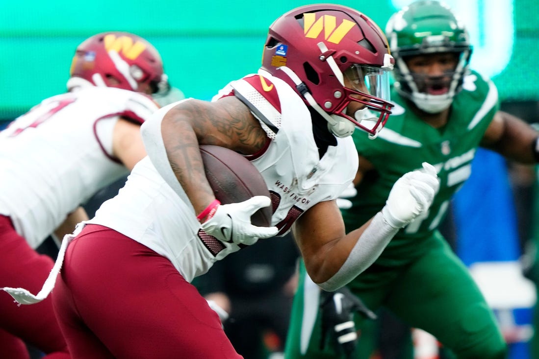 Washington Commanders running back Antonio Gibson (24) runs with the ball at MetLife Stadium, in East Rutherford, Sunday December 24, 2023.