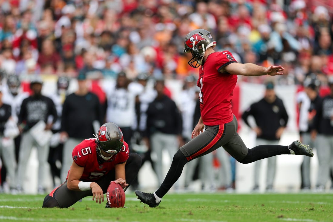 Dec 24, 2023; Tampa, Florida, USA;  Tampa Bay Buccaneers place kicker Chase McLaughlin (4) kicks a field goal held by punter Jake Camarda (5) against the Jacksonville Jaguars in the first quarter at Raymond James Stadium. Mandatory Credit: Nathan Ray Seebeck-USA TODAY Sports